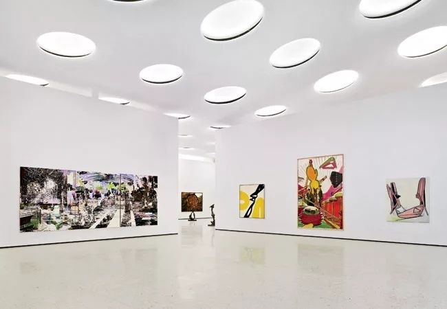 Lyst galleri med flere abstrakte og fargerike kunstverk på veggene